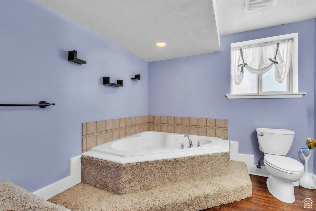 Bathroom featuring a bath and wood finished floors
