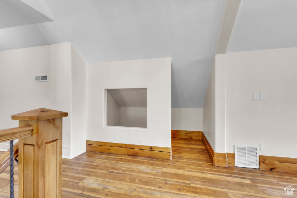 Bonus room featuring wood finished floors and vaulted ceiling