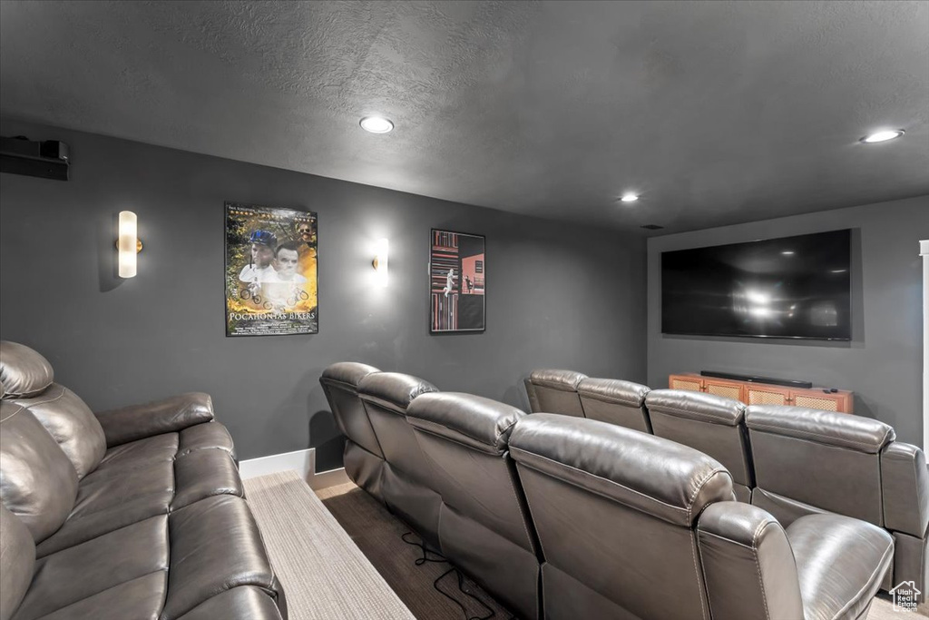 Home theater room featuring recessed lighting, wood finished floors, and a textured ceiling