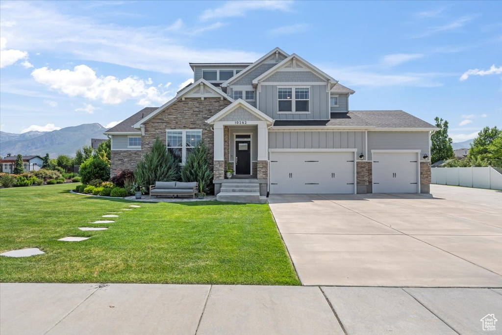 Craftsman inspired home featuring driveway, board and batten siding, stone siding, and a mountain view