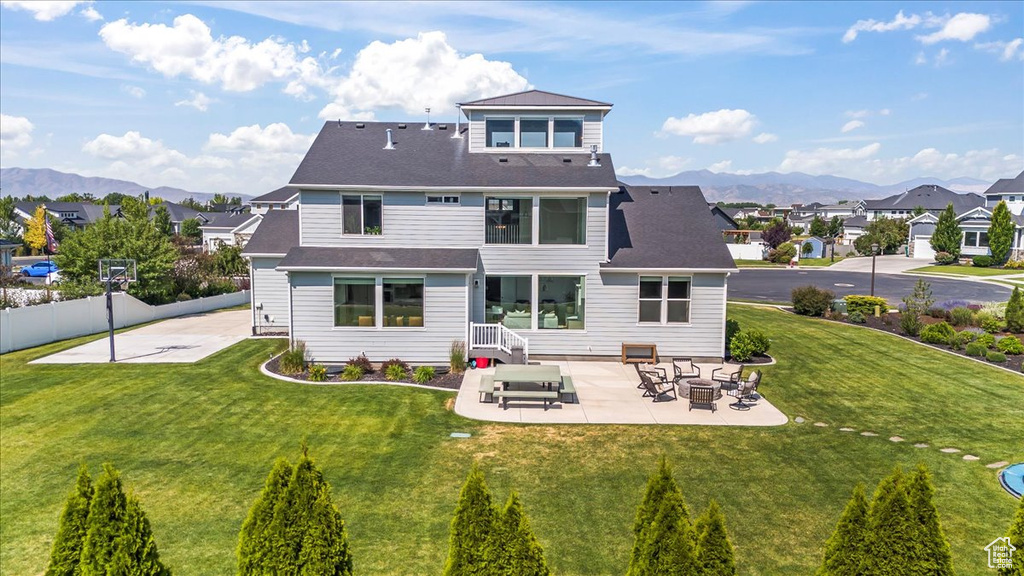 Rear view of property featuring a patio area, a residential view, and a mountain view