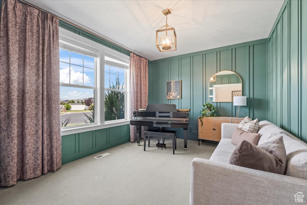 Sitting room with a decorative wall, plenty of natural light, and carpet flooring