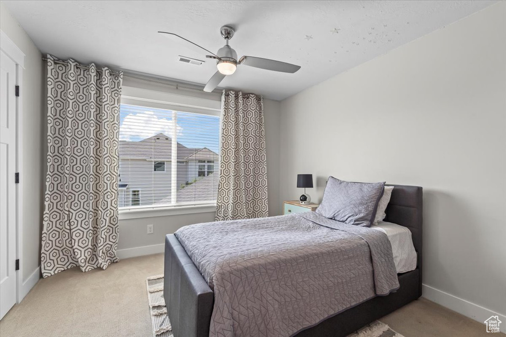 Carpeted bedroom with baseboards and ceiling fan