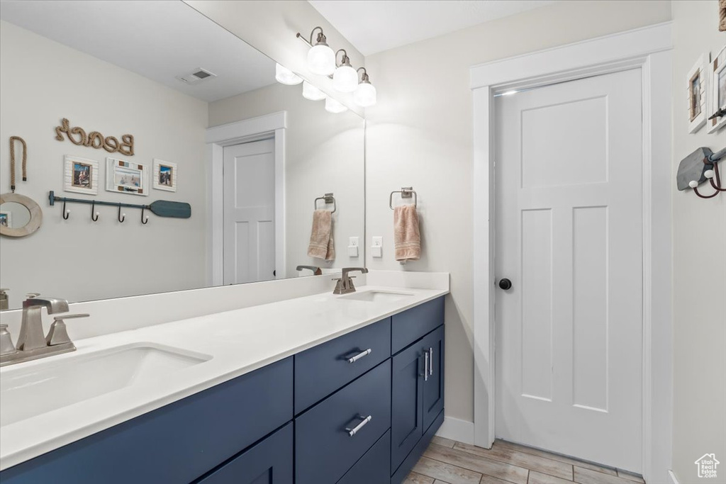 Bathroom featuring double vanity and wood finished floors