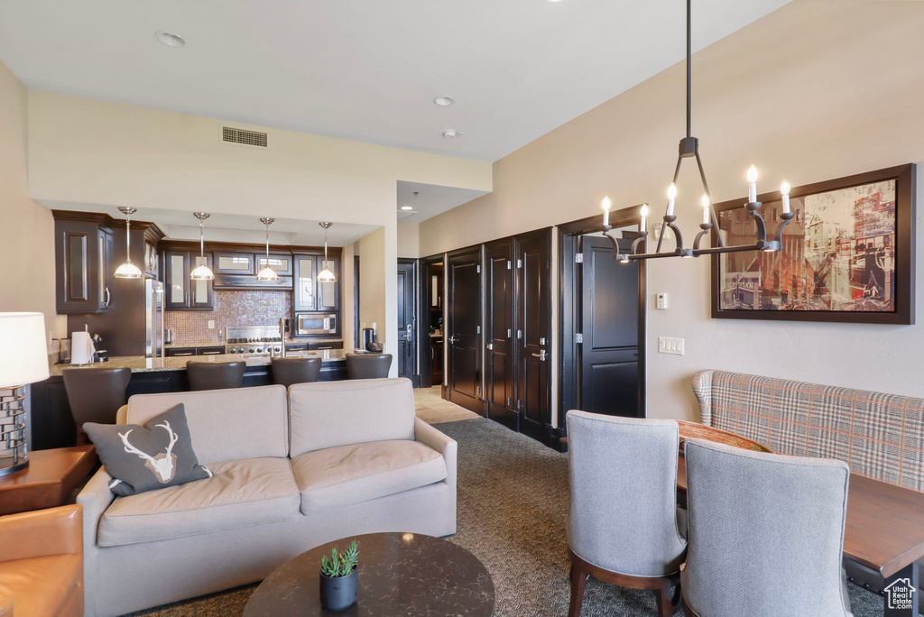 Carpeted living room featuring a chandelier and recessed lighting