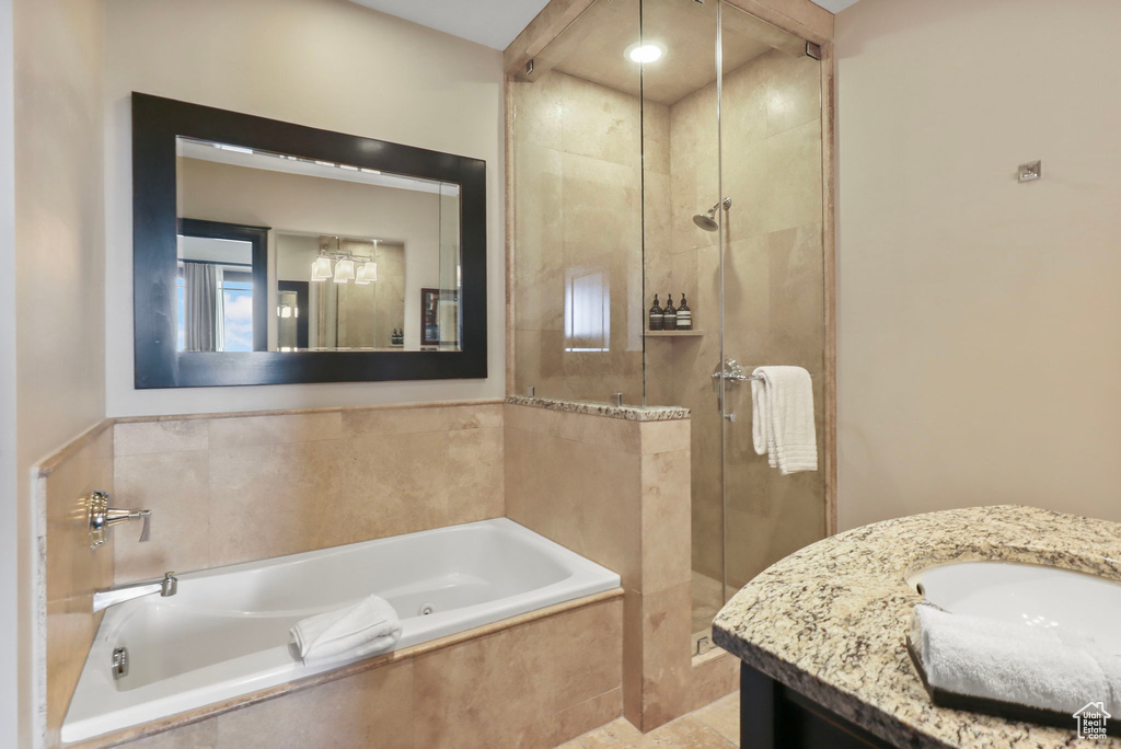 Full bath with a shower stall, vanity, and a garden tub