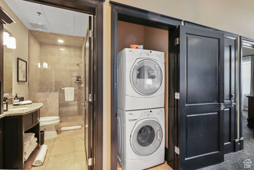 Laundry room with stacked washing machine and dryer