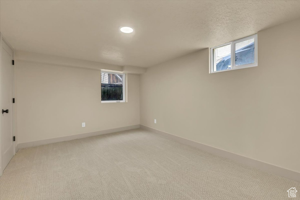 Basement with light carpet, healthy amount of natural light, and recessed lighting