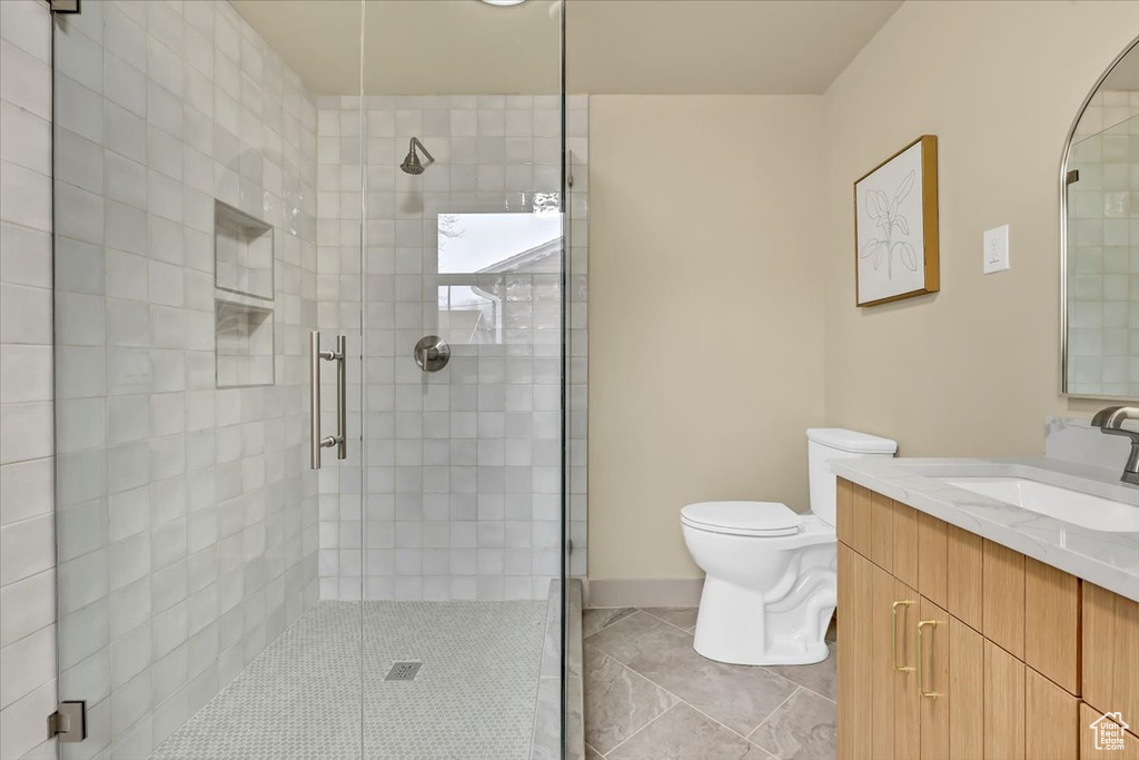 Full bath with a stall shower, vanity, and tile patterned flooring