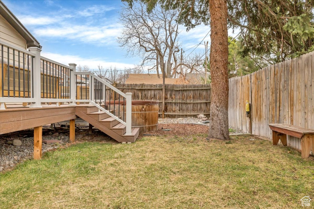 Fenced backyard featuring stairs and a deck