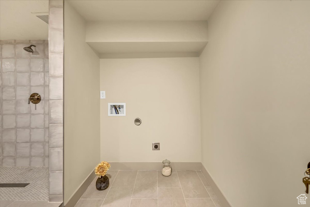 Washroom with electric dryer hookup, tile patterned flooring, and washer hookup