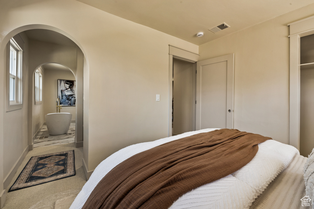 Bedroom featuring carpet and arched walkways