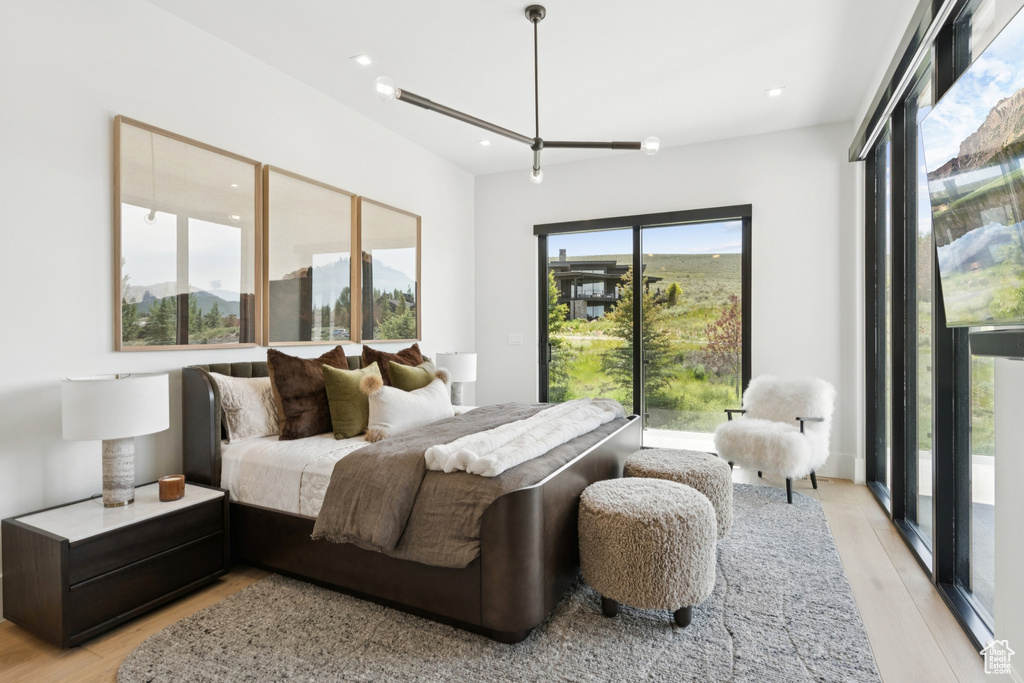 Bedroom featuring access to exterior, light wood finished floors, a mountain view, and recessed lighting