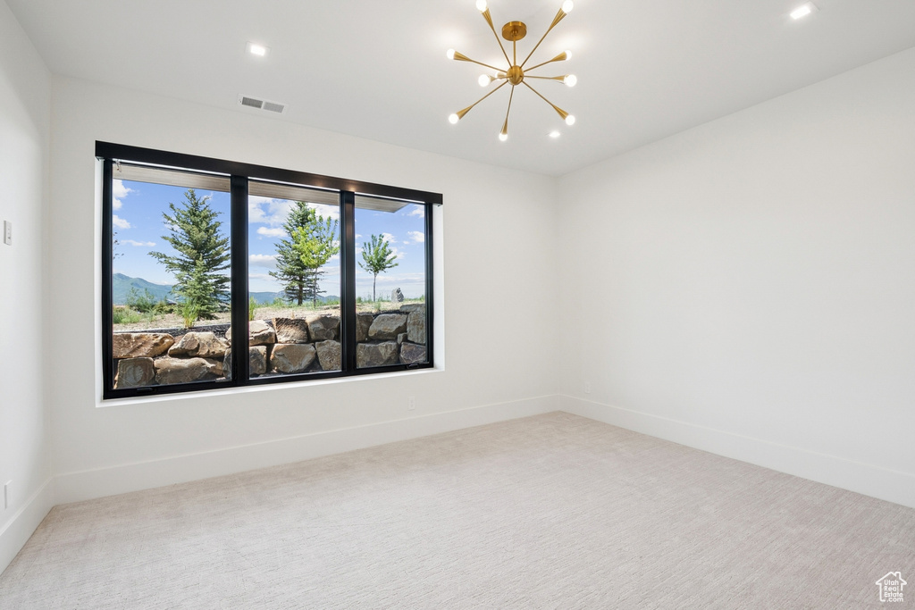 Carpeted spare room featuring a chandelier and recessed lighting