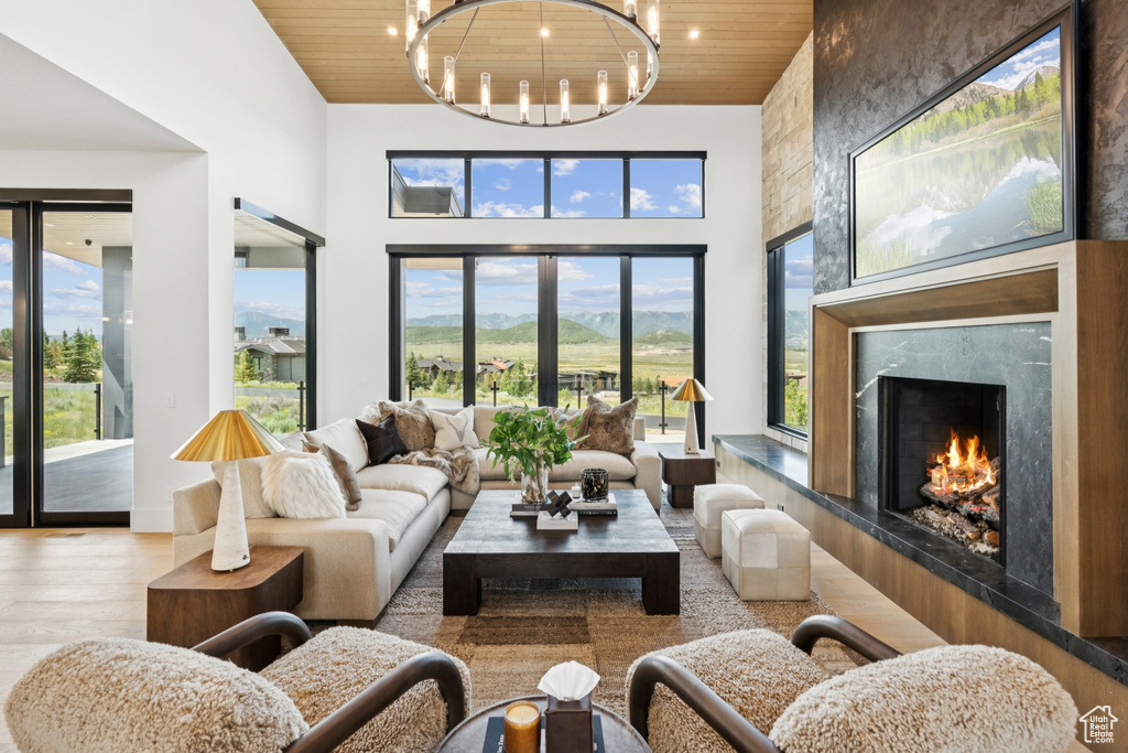 Living area with wood ceiling, a high end fireplace, wood finished floors, and a high ceiling