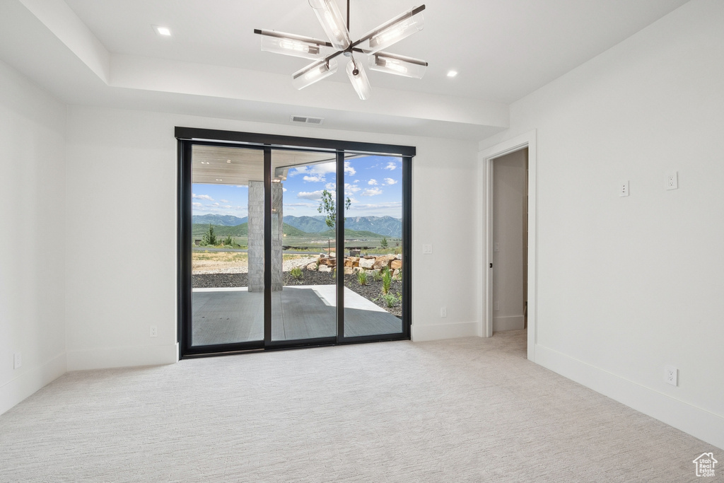 Carpeted spare room with a mountain view and recessed lighting