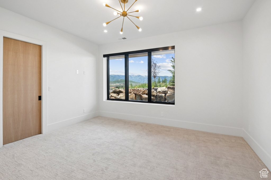 Carpeted spare room featuring a chandelier and recessed lighting