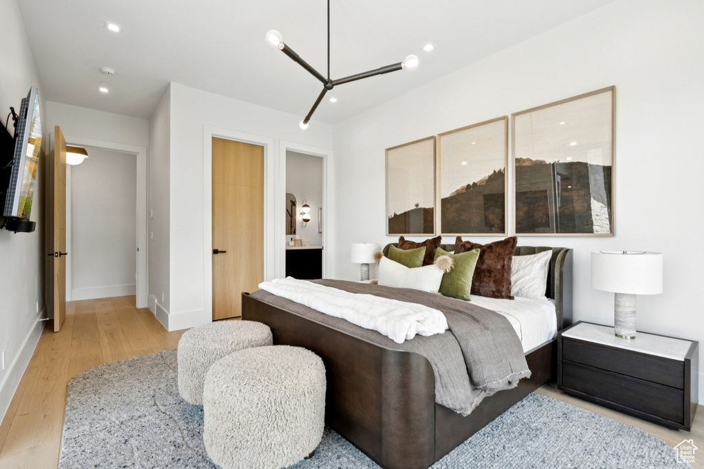 Bedroom with light wood-type flooring, connected bathroom, and recessed lighting