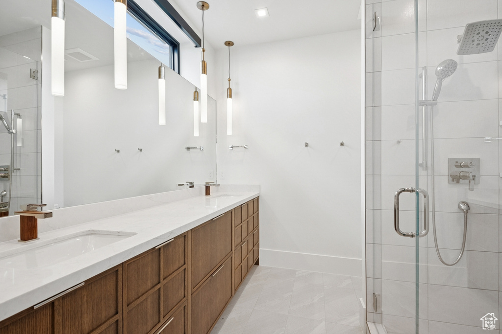 Bathroom featuring a stall shower and double vanity
