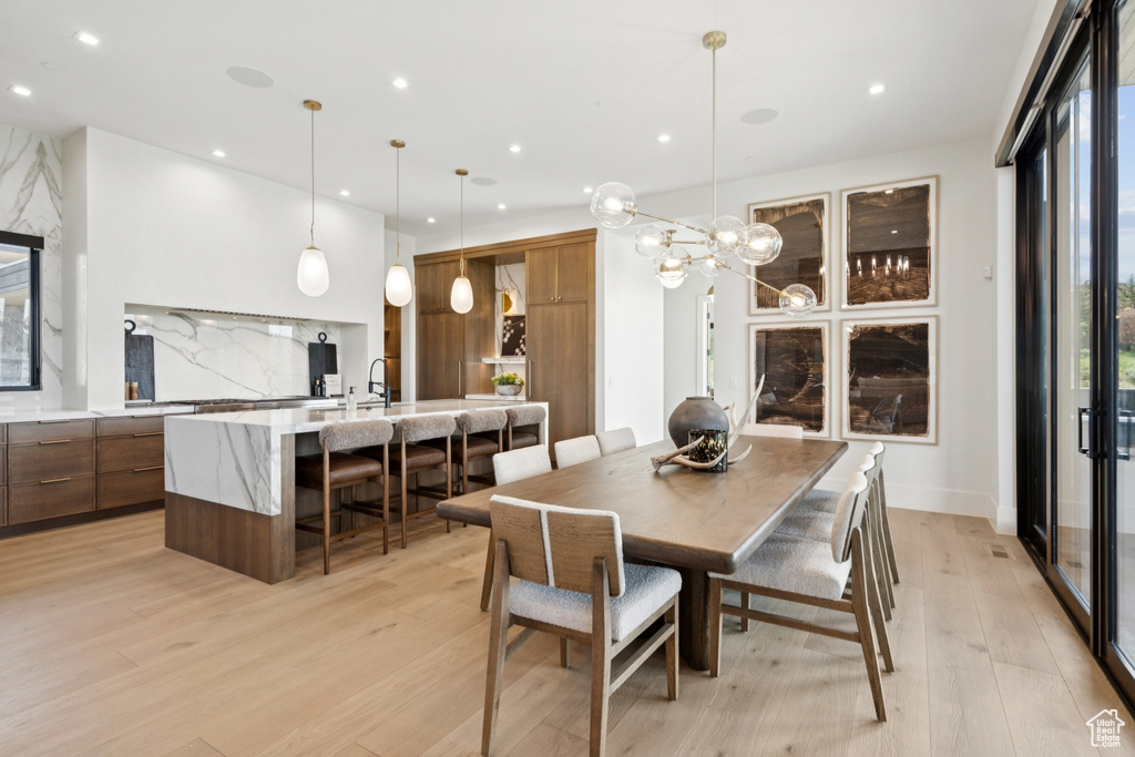 Dining space with light wood-style flooring, recessed lighting, and a chandelier