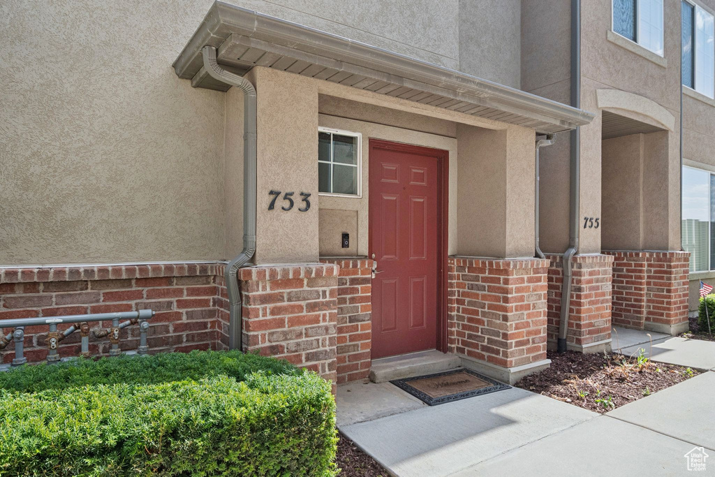 Property entrance with stucco siding and brick siding