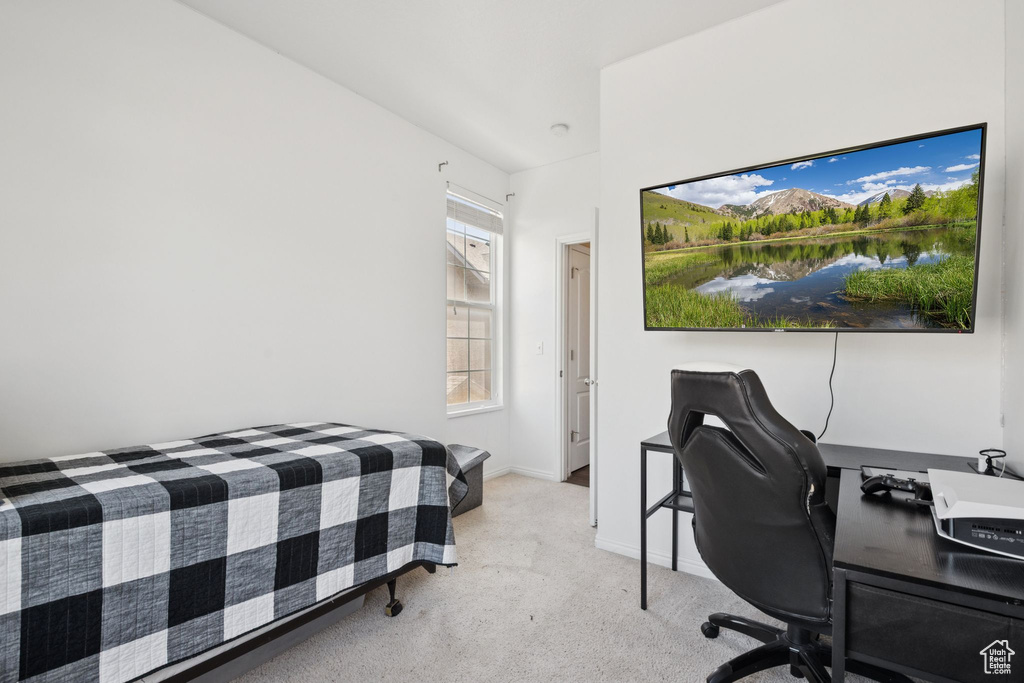 Bedroom with carpet floors and an office area