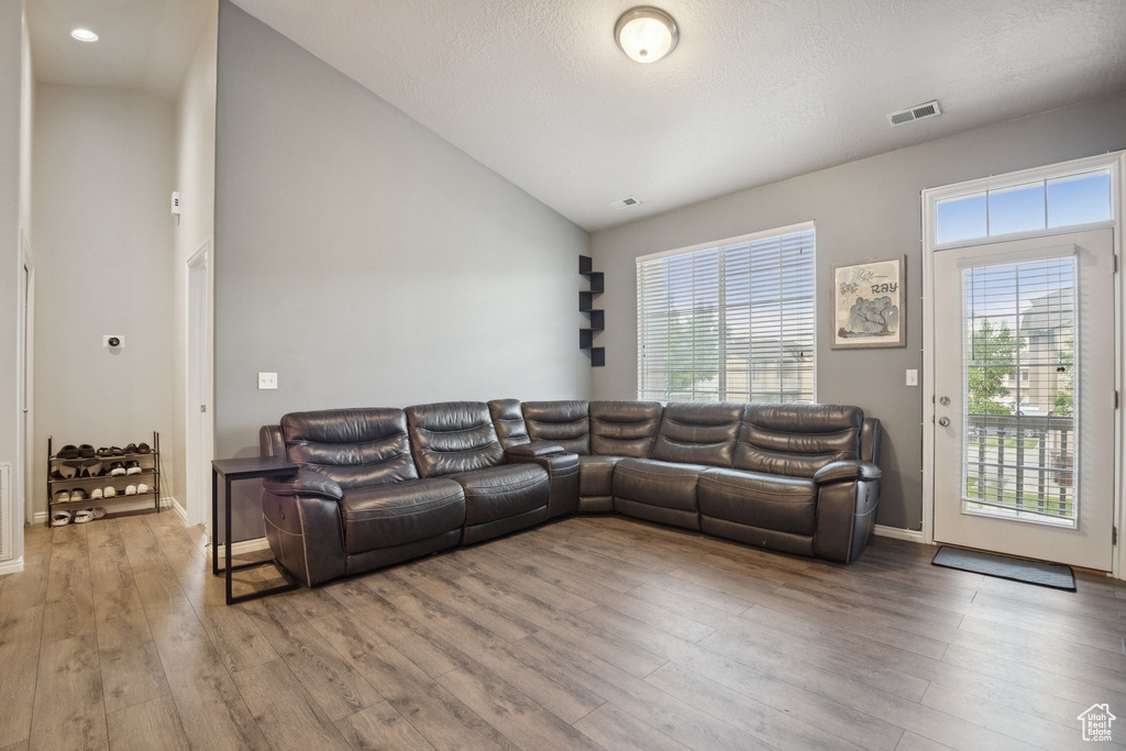 Living area with wood finished floors and lofted ceiling