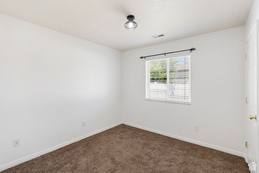Carpeted empty room with baseboards
