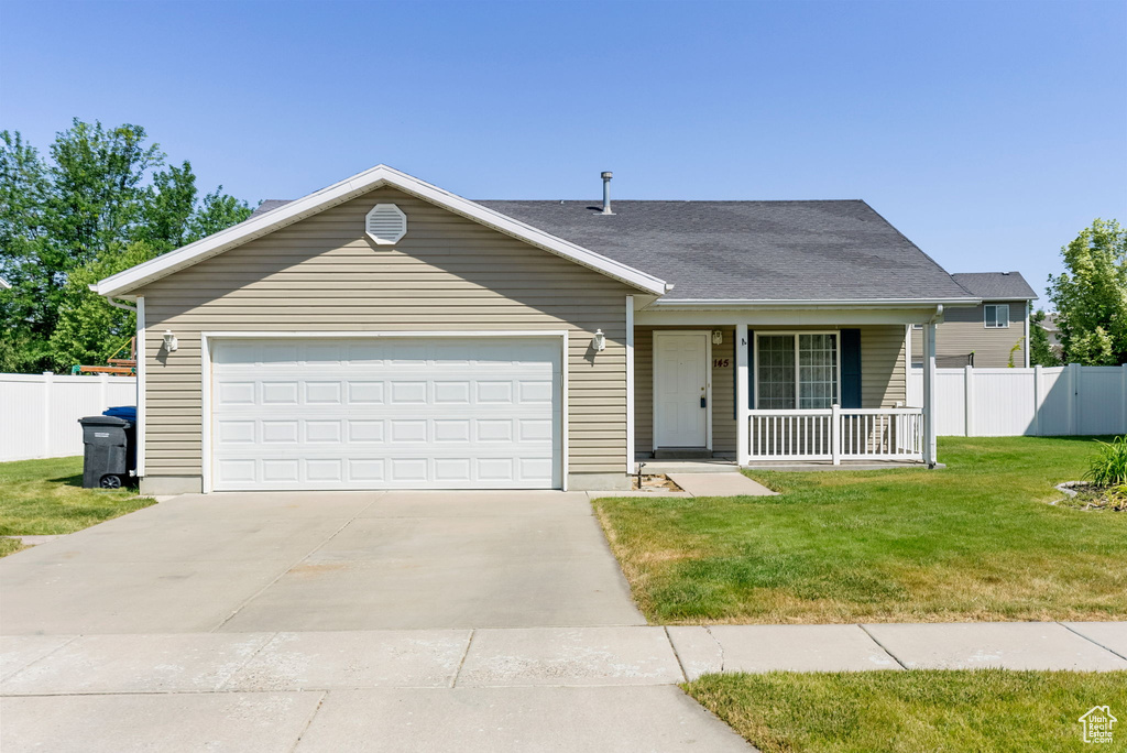 View of front of house with a porch, driveway, and an attached garage