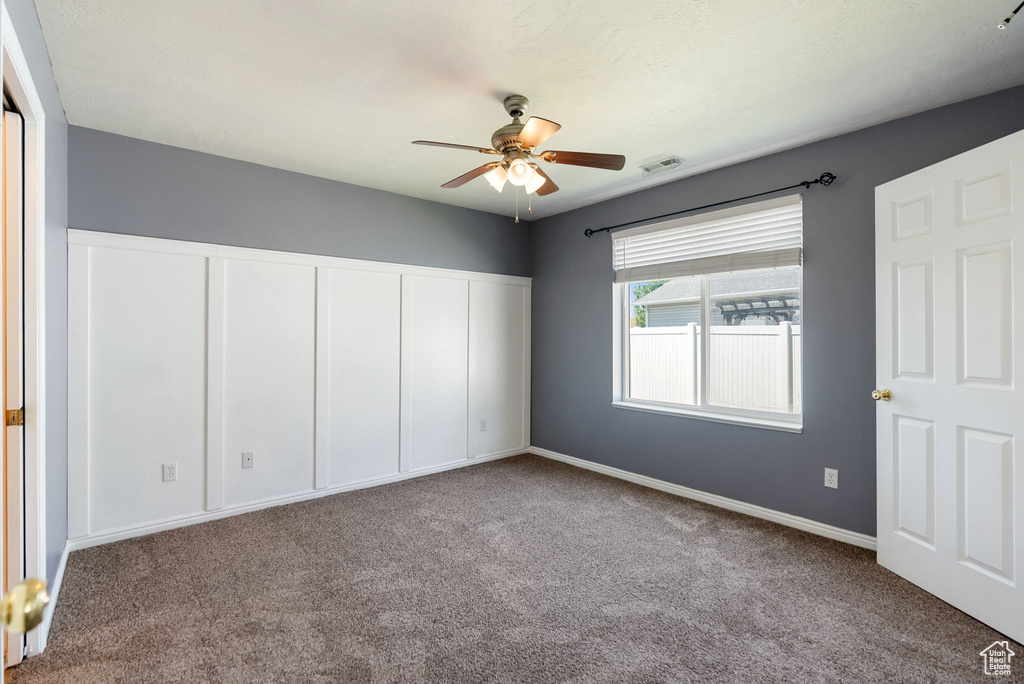 Unfurnished bedroom featuring carpet, a closet, and a ceiling fan