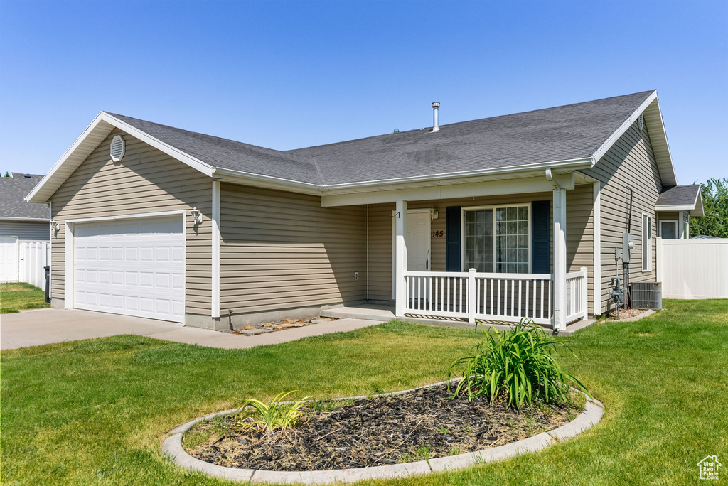 Single story home with a porch, an attached garage, and concrete driveway