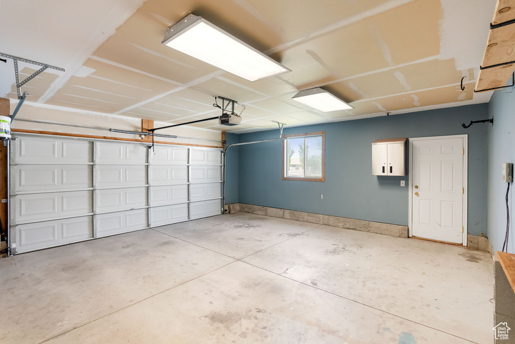 Garage with baseboards and a garage door opener
