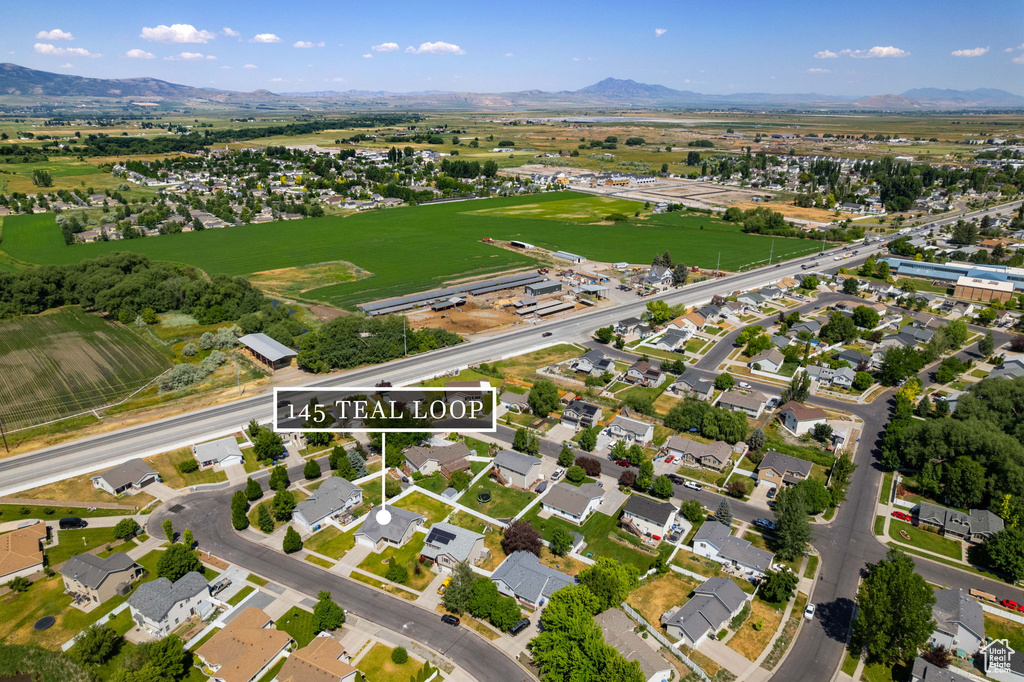 Aerial view of property\'s location with a mountain backdrop and nearby suburban area
