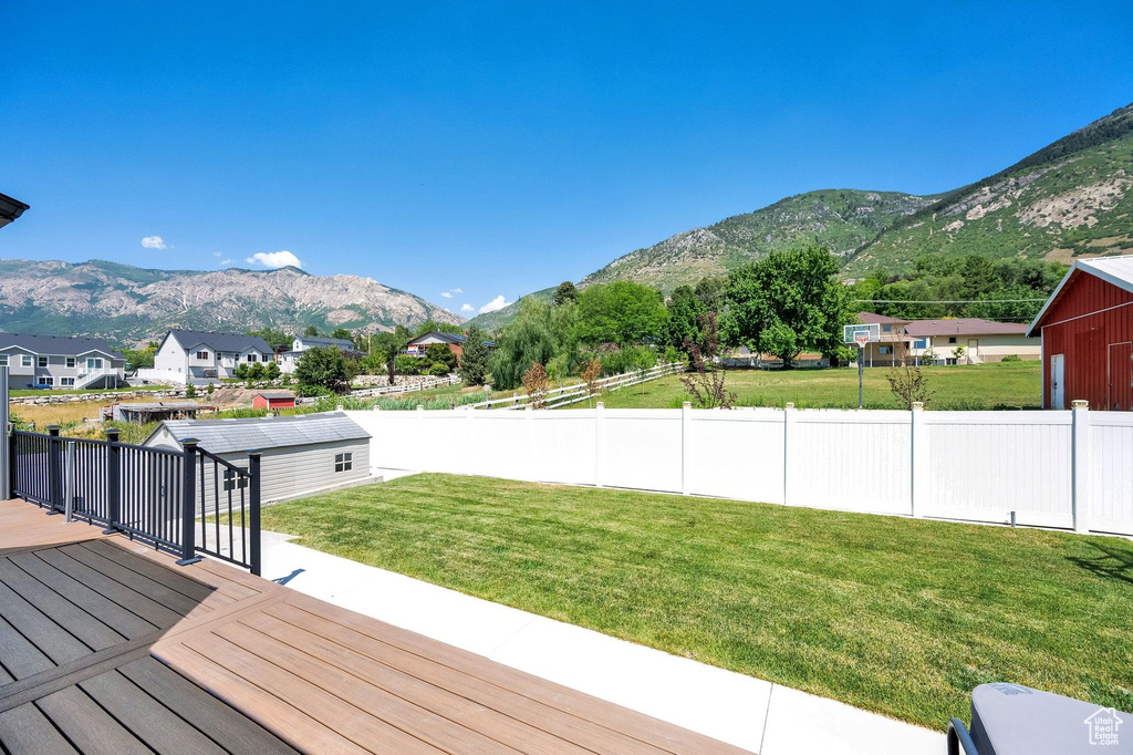 View of yard featuring a deck with mountain view and an outdoor structure
