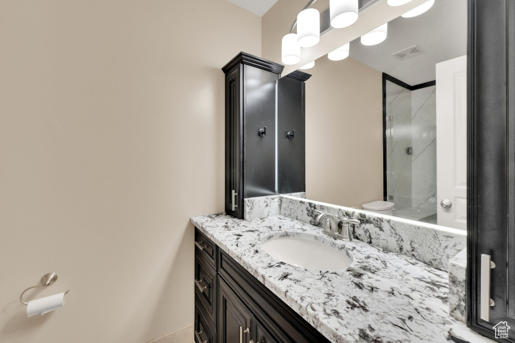Bathroom featuring vanity and a shower with door