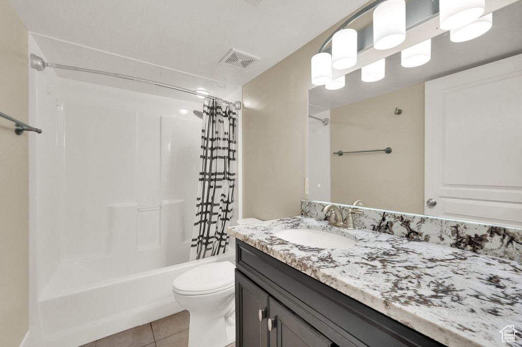 Bathroom featuring vanity, tile patterned floors, and shower / bath combo with shower curtain