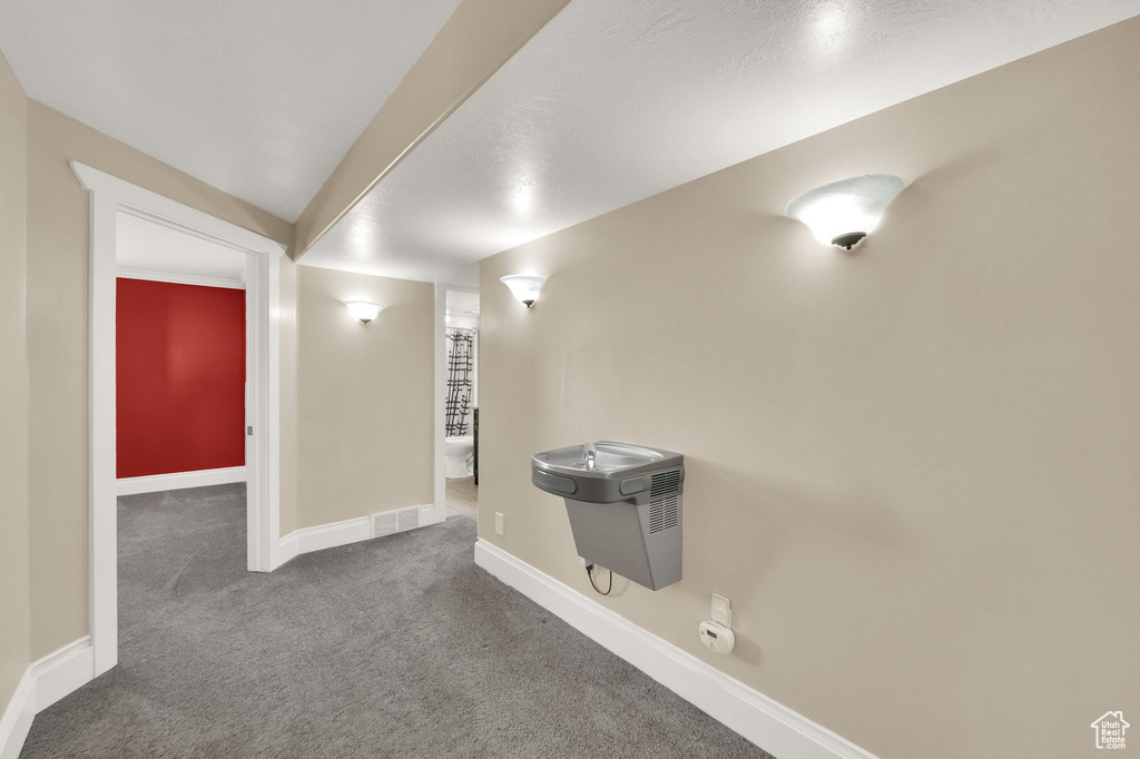 Hallway featuring carpet flooring and baseboards