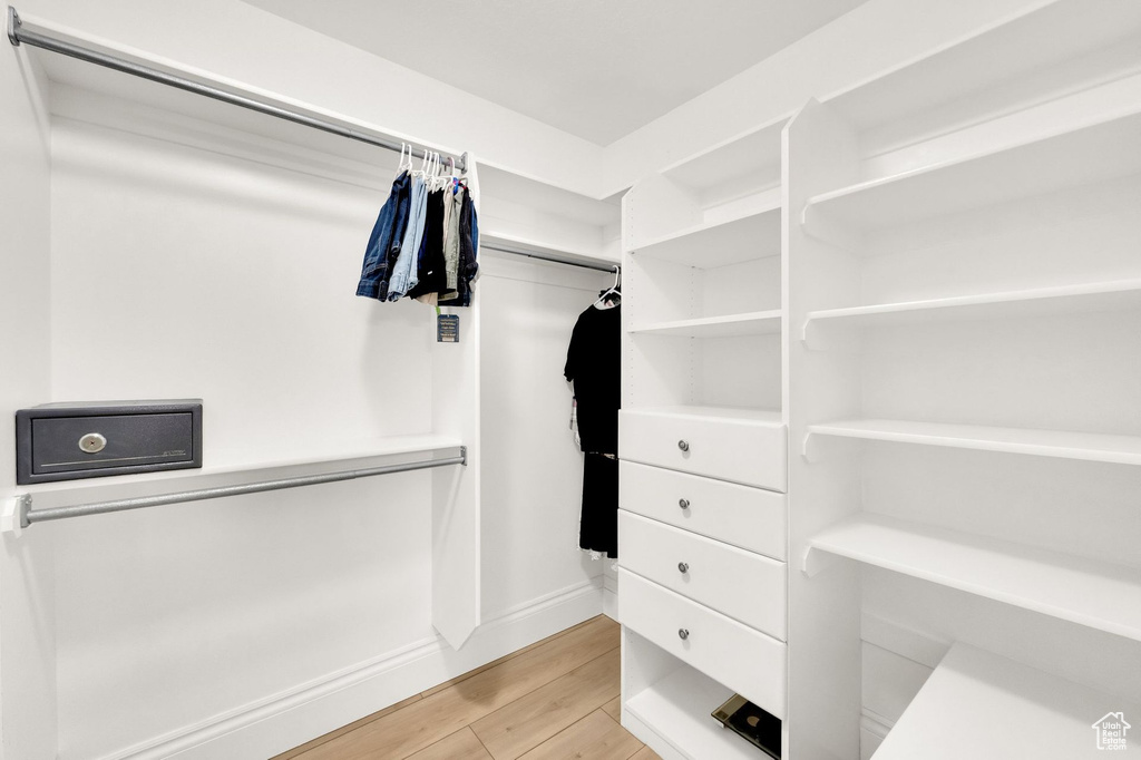 Walk in closet with light wood-type flooring