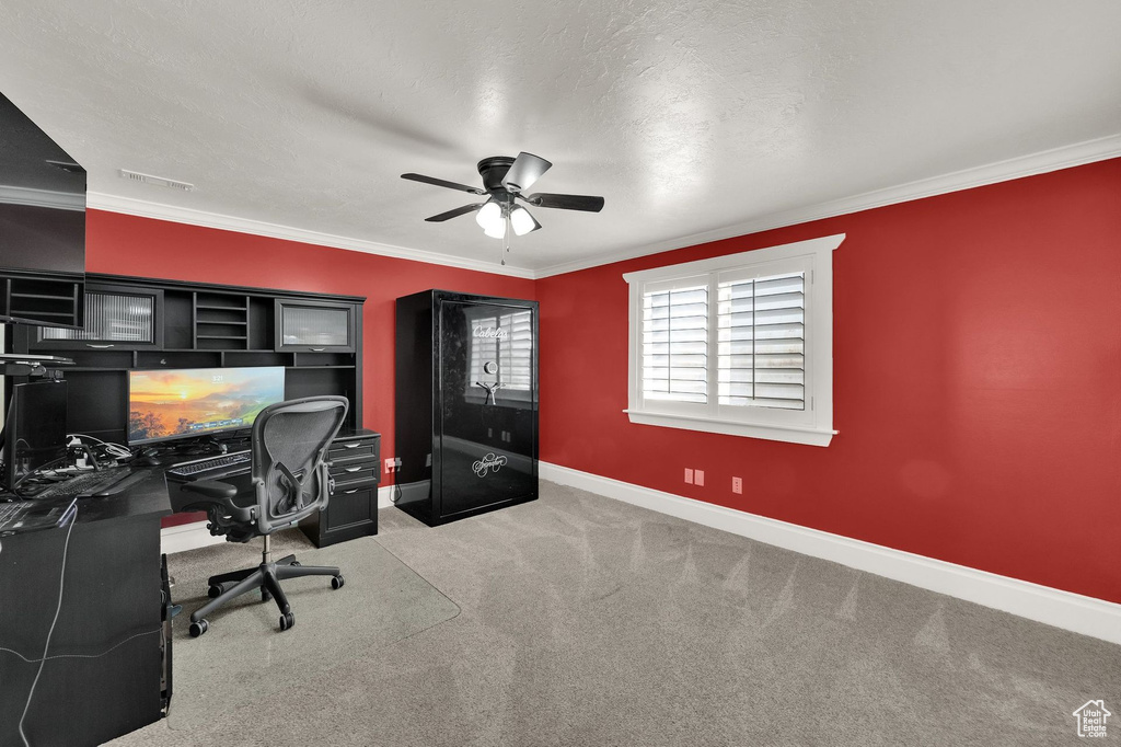Carpeted office space featuring ceiling fan and ornamental molding