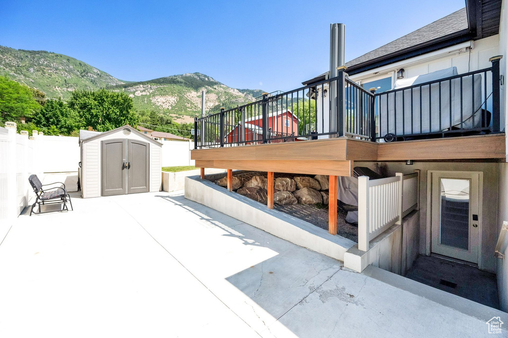 View of patio / terrace with a storage unit and a deck with mountain view