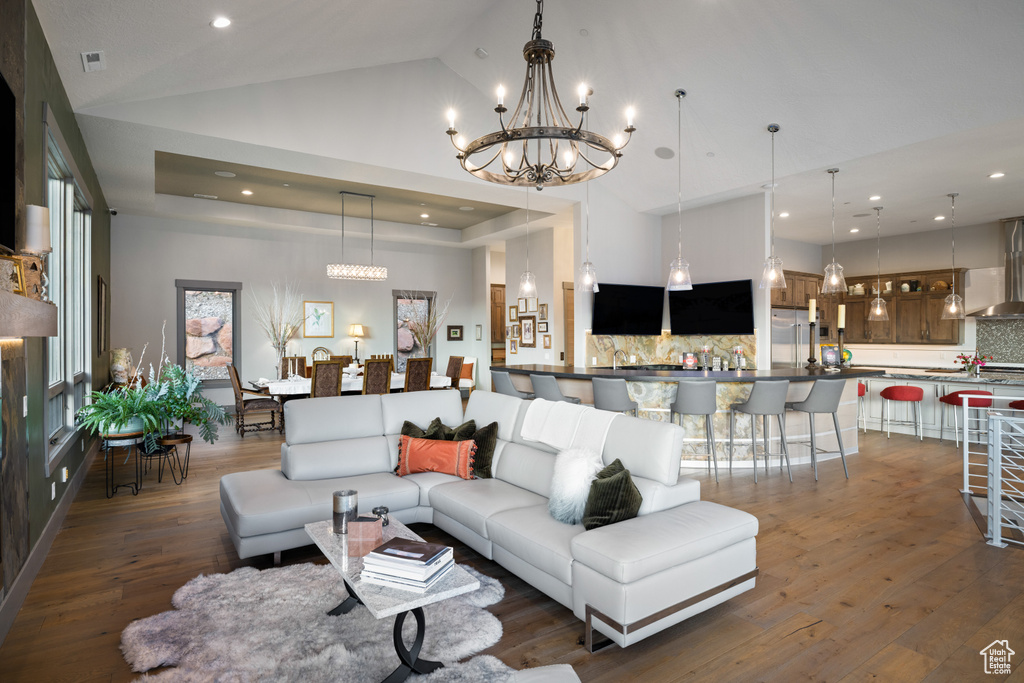 Living area featuring a chandelier, dark wood-style floors, recessed lighting, and lofted ceiling