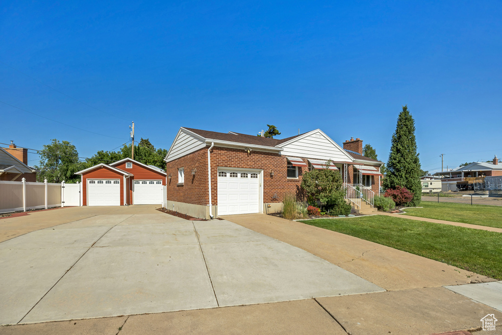 Ranch-style home with brick siding, a chimney, and an outbuilding