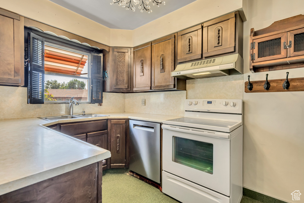 Kitchen with electric range, under cabinet range hood, stainless steel dishwasher, light countertops, and decorative backsplash