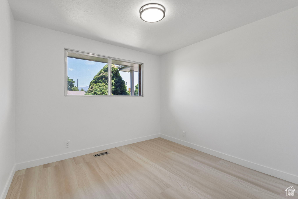 Empty room with light wood-style floors and baseboards