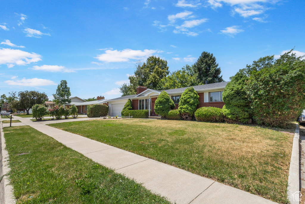Ranch-style house with an attached garage and a front lawn