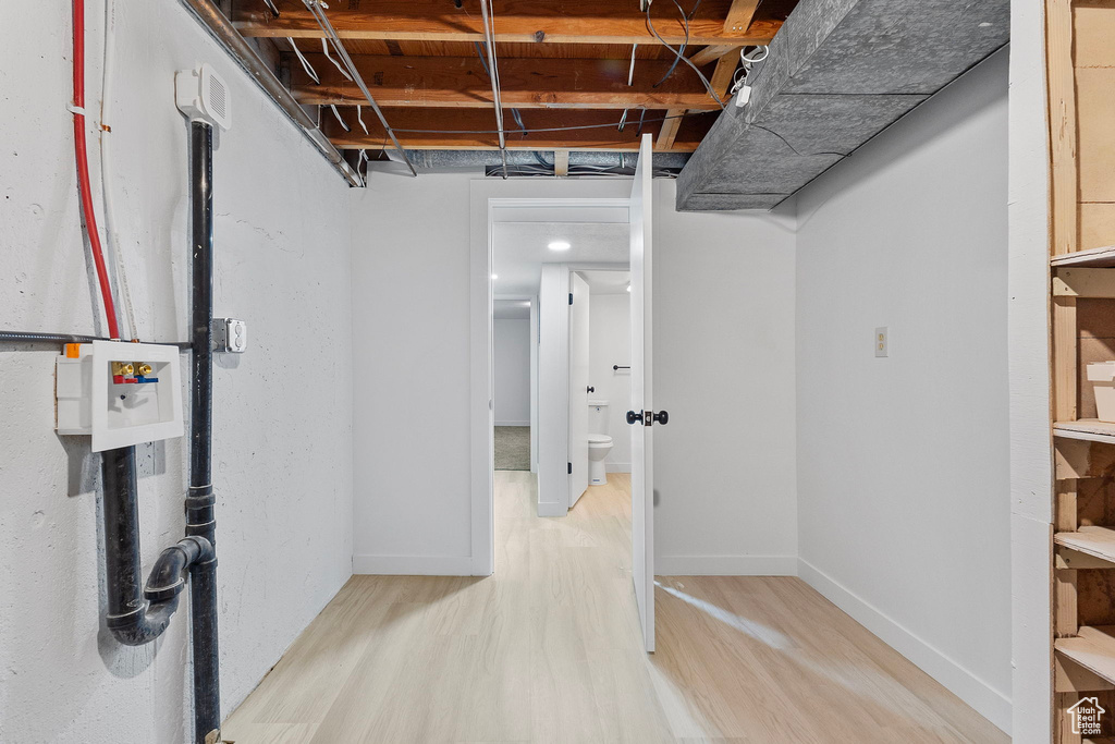 Finished below grade area featuring light wood-type flooring and refrigerator