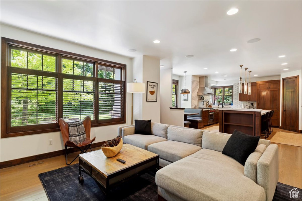 Living area with light wood finished floors and recessed lighting