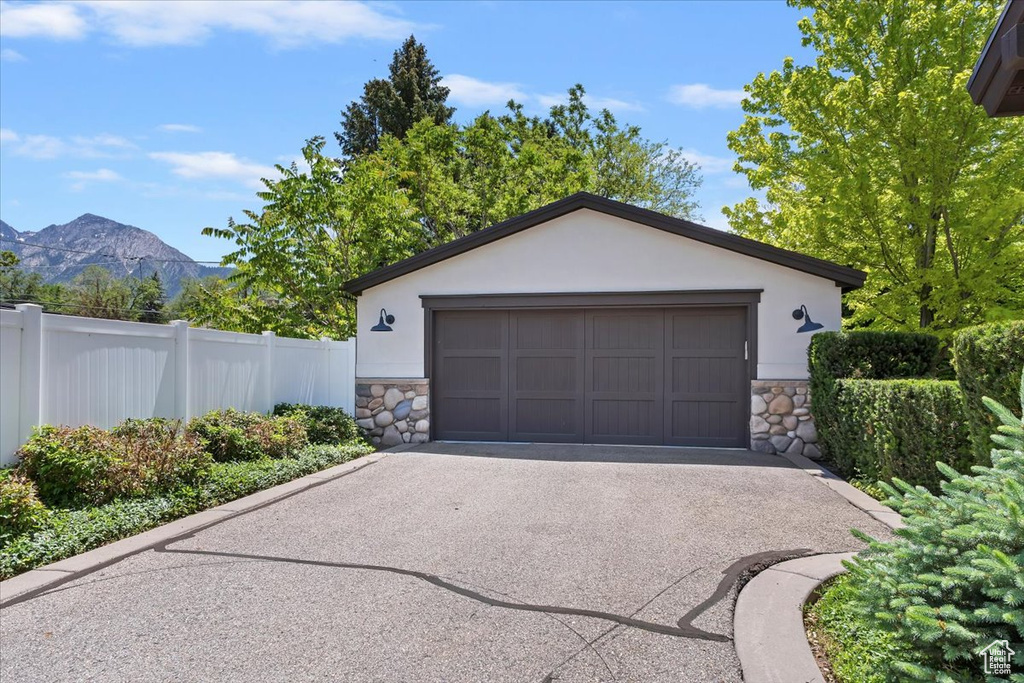 Garage with a mountain view, driveway, and a wall mounted AC