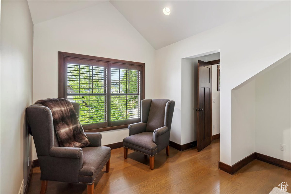 Sitting room with light wood-style floors, high vaulted ceiling, and recessed lighting