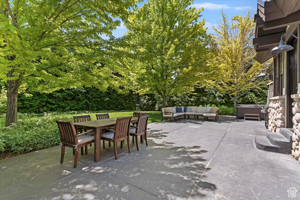 View of patio / terrace with outdoor dining area, outdoor lounge area, and a hot tub